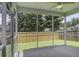 A screened porch offers views of a fenced backyard with green grass and mature shade trees at 9680 Spencer Woods Rd, Ladson, SC 29456