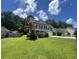 A well maintained two-story home featuring a lush lawn and complemented by mature trees on a sunny day at 1039 Steelechase Ln, Hanahan, SC 29410