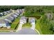 Aerial view of a residential neighborhood with houses that have manicured lawns and a serene pond surrounded by lush trees at 105 Plowden Mill Ct, Summerville, SC 29485