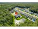 Aerial view highlighting a residential neighborhood surrounded by lush greenery and a pond at 105 Plowden Mill Ct, Summerville, SC 29485