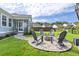Landscaped backyard featuring a cozy firepit area, stone pavers, and six Adirondack chairs at 105 Plowden Mill Ct, Summerville, SC 29485