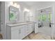 Bathroom featuring dual sinks, white cabinets and a view into the Primary bedroom through an open door at 105 Plowden Mill Ct, Summerville, SC 29485