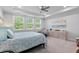 Bright bedroom featuring neutral tones, large windows, tray ceiling, and stylish furnishings at 105 Plowden Mill Ct, Summerville, SC 29485