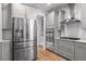 Modern kitchen with stainless steel appliances, gray cabinetry, and hardwood floors, providing a sleek cooking space at 105 Plowden Mill Ct, Summerville, SC 29485
