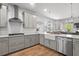Open-concept kitchen featuring stainless appliances, gray cabinets, and quartz counters at 105 Plowden Mill Ct, Summerville, SC 29485