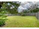 Spacious, fenced backyard with a well-maintained lawn and mature trees offers privacy and space for outdoor activities at 1052 Whitlow Blvd, Summerville, SC 29483