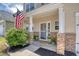 Inviting front porch with brick accents, American flag, and attractive landscaping at 1052 Whitlow Blvd, Summerville, SC 29483