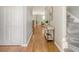 Well-lit hallway with hardwood floors, leading to the staircase and other rooms at 1052 Whitlow Blvd, Summerville, SC 29483