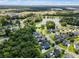 Community aerial view with houses, streets, mature trees and a pond in the background at 1070 Moss Grove Dr, Moncks Corner, SC 29461