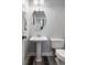 This powder room features a sleek pedestal sink, a round mirror, and modern fixtures at 1070 Moss Grove Dr, Moncks Corner, SC 29461