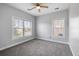Bright bedroom with gray carpet, neutral walls, two large windows and a ceiling fan at 1070 Moss Grove Dr, Moncks Corner, SC 29461