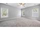 A bright, open bedroom features three windows, neutral colors, and plush carpet at 1070 Moss Grove Dr, Moncks Corner, SC 29461