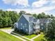 Two-story blue home with double balconies, mature landscaping, and well-manicured lawn at 1070 Moss Grove Dr, Moncks Corner, SC 29461