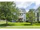 Charming two-story home featuring a double balcony, tidy lawn, and mature shade trees at 1070 Moss Grove Dr, Moncks Corner, SC 29461