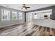 This open living room features lots of windows, neutral colors, and lovely wood-look floors at 1070 Moss Grove Dr, Moncks Corner, SC 29461