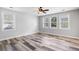 An open living room features lots of windows, neutral colors, and lovely wood-look floors at 1070 Moss Grove Dr, Moncks Corner, SC 29461