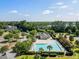 An aerial view of the community pool with lounge chairs and clubhouse is surrounded by palms and crepe myrtles at 1070 Moss Grove Dr, Moncks Corner, SC 29461
