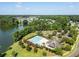 A community pool area is surrounded by a lake and mature trees, a playground in the distance at 1070 Moss Grove Dr, Moncks Corner, SC 29461