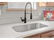 Close-up of a stainless steel kitchen sink with modern black faucet and stylish gray tiled backsplash at 109 Ashdown Dr, Summerville, SC 29483
