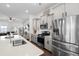 Open-concept kitchen with stainless steel appliances, quartz countertops, and seamless flow into the living area at 109 W Respite Ln, Summerville, SC 29483