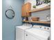 Well-organized laundry room with wooden shelves, cabinetry, and modern washer and dryer at 109 W Respite Ln, Summerville, SC 29483