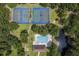 Aerial view of a community pool and tennis courts nestled amongst verdant trees, adjacent to a serene pond at 109 Waveney Cir, Goose Creek, SC 29445