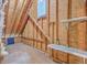 Unfinished attic space featuring exposed wood rafters, a window, and built-in shelving, offering potential for storage at 109 Waveney Cir, Goose Creek, SC 29445