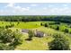 Aerial view of a home and detached garage, with mature trees, large grassy area, and fenced yard at 1111 Sandy Springs Circle, Walterboro, SC 29488