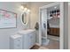 Bathroom with gray vanity, oval mirror, and decorative floral artwork on the wall at 1111 Sandy Springs Circle, Walterboro, SC 29488