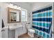 Bright bathroom featuring a pedestal sink, window, and a blue-striped shower curtain at 1111 Sandy Springs Circle, Walterboro, SC 29488