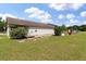 Exterior back of home showcasing a covered porch with a lush green lawn and blue sky at 1111 Sandy Springs Circle, Walterboro, SC 29488