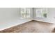 Sunlight streams through windows accentuating wood floors in an empty bedroom at 113 Cozy Nest Way, Summerville, SC 29483