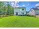 Expansive backyard featuring a lush green lawn, patio seating, and a privacy fence at 115 Cooper Dr, Summerville, SC 29483