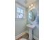 Light and airy powder room featuring a pedestal sink, decorative mirror, and natural light at 115 Cooper Dr, Summerville, SC 29483