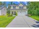 Beautiful two-story home featuring manicured front yard and attached garage on a sunny day at 115 Cooper Dr, Summerville, SC 29483