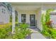 Charming front porch with black welcome door, chairs, and beautiful flowering plants at 115 Cooper Dr, Summerville, SC 29483