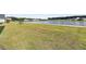 Spacious backyard featuring lush green grass, a tranquil pond, and mature landscaping at 1213 Locals St, Summerville, SC 29485