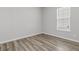 A minimalist bedroom design showcasing wood flooring, a window with blinds, and neutral paint at 1213 Locals St, Summerville, SC 29485