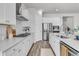 Modern kitchen featuring white cabinetry, stainless steel appliances, and a sleek range hood for a contemporary look at 1213 Locals St, Summerville, SC 29485