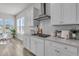 Modern kitchen with white cabinets, stainless steel range hood, and bright natural light, creating a cheerful cooking space at 1213 Locals St, Summerville, SC 29485