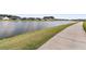 Scenic pond with a paved walkway, surrounded by green grass and well-kept landscaping at 1213 Locals St, Summerville, SC 29485