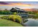 Sunset view of wooden gazebo over pond with grassy landscaping and nice foliage at 1213 Locals St, Summerville, SC 29485
