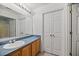 Neutral bathroom featuring a large mirror, oak cabinets, and double door closet at 122 Stewart Pl, Summerville, SC 29485