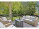 Relax on this home's outdoor deck with a fire pit, stylish outdoor seating, and a beautiful decorative rug at 1228 Walleye Cor, Charleston, SC 29414