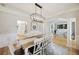 Spacious dining room featuring a rustic wood table, white chairs, decorative lighting, and stylish accents at 1228 Walleye Cor, Charleston, SC 29414