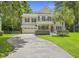 Charming two-story home with a well-manicured lawn, long driveway, attached garage and a delightful red front door at 1228 Walleye Cor, Charleston, SC 29414