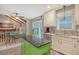 Well-lit kitchen featuring a green island, white countertops and cabinets, stainless steel appliances, and access to the backyard at 125 Sumners Aly, Summerville, SC 29485