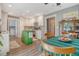 Bright kitchen with a green island, white cabinets, modern appliances, dining area, and a laundry room in the back at 125 Sumners Aly, Summerville, SC 29485
