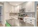 Open kitchen layout featuring white cabinetry, stainless steel appliances, and views into the dining and living area at 125 Sumners Aly, Summerville, SC 29485