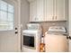 Convenient laundry room featuring modern, front-loading washer and dryer with white cabinets, and a door to the outside at 125 Sumners Aly, Summerville, SC 29485